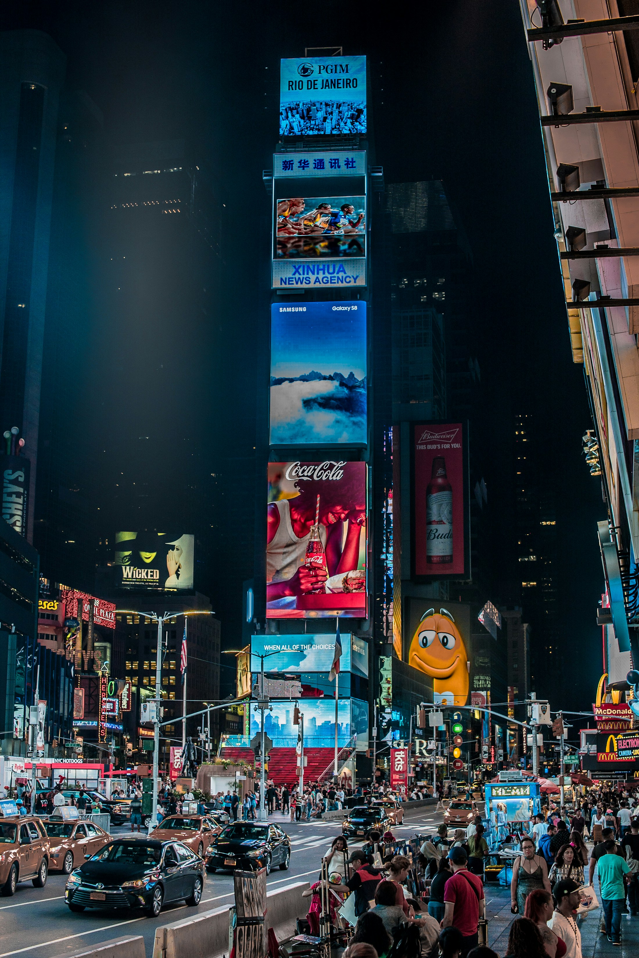 Écrans géants et foule à Times Square de nuit